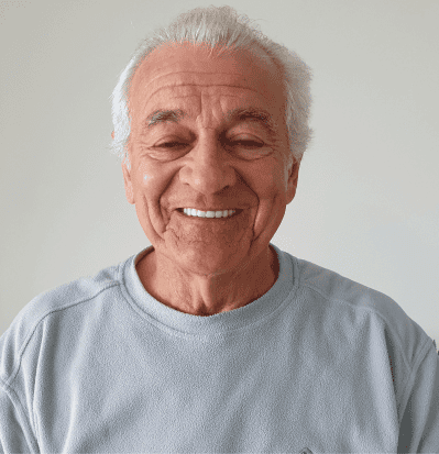 Smiling Man in his 70's with a grey T shirt on