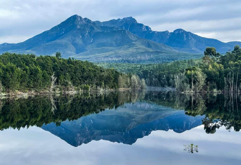 a lake surrounded by trees and mountains